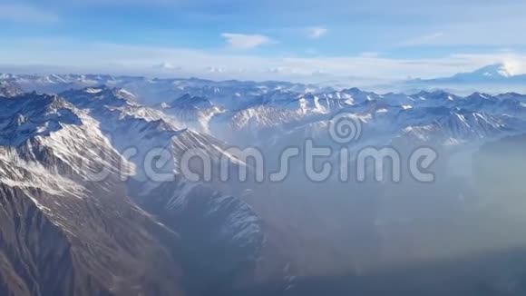 巨大的空中无人驾驶飞机在多云的冬季景观上拍摄覆盖雪的石头山悬崖巨大的链条范围视频的预览图