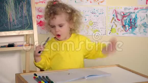 情绪化的金发女孩用铅笔在桌子上的书上画画视频的预览图