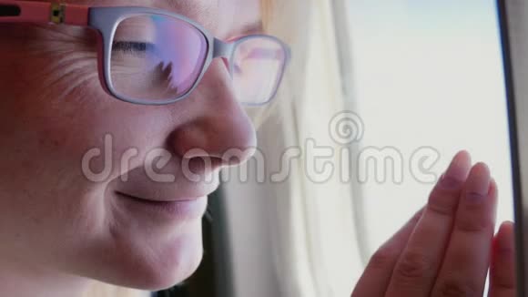 戴眼镜的女人的肖像看着飞机的窗户旅行的乐趣视频的预览图