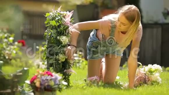 美丽的女模特金发微笑的女孩在快乐的夏天用粉色和白色的花朵组成了一个温柔的花朵视频的预览图