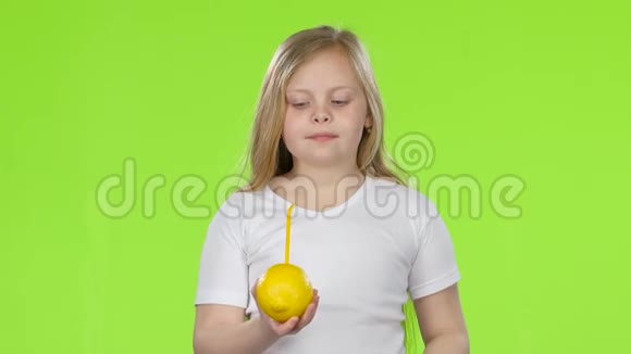 小女孩拿着一个柠檬用吸管从柠檬里喝果汁绿色屏幕视频的预览图