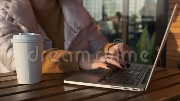 女人拿着一杯咖啡在笔记本电脑里工作视频的预览图