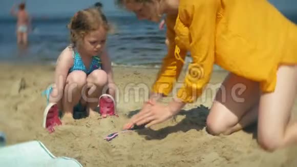 小女孩女妈妈在沙滩上玩沙子视频的预览图
