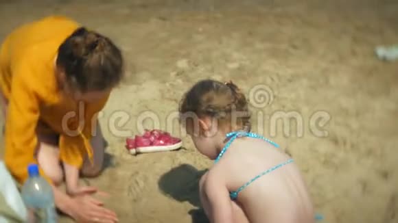 小女孩女妈妈在沙滩上玩沙子视频的预览图