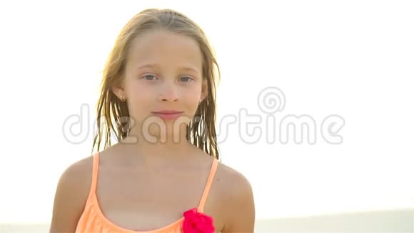 小女孩看镜头和微笑背景美丽的天空和大海的肖像流动人口视频的预览图