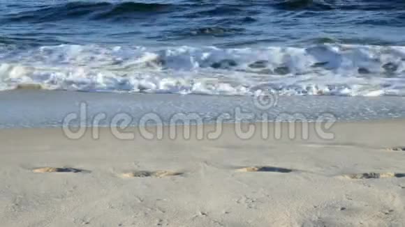 沙滩上有波浪和脚印视频的预览图