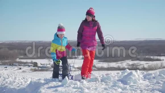 幸福的家庭母亲和孩子女儿在户外散步雪橇妈妈和孩子们的美丽家庭视频的预览图