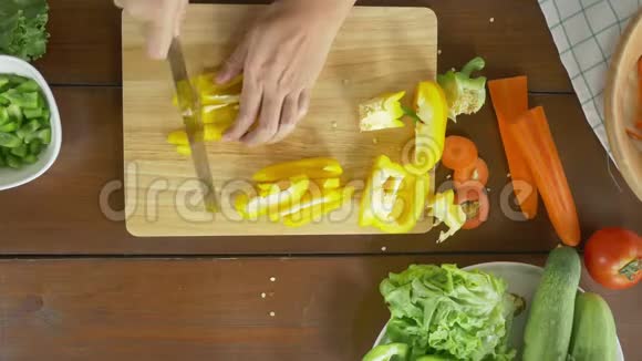 女性主厨制作沙拉健康食品和在厨房的砧板上切黄瓜的最佳景观视频的预览图