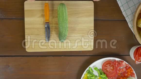 女性主厨制作沙拉健康食品和在厨房的砧板上切黄瓜的最佳景观视频的预览图
