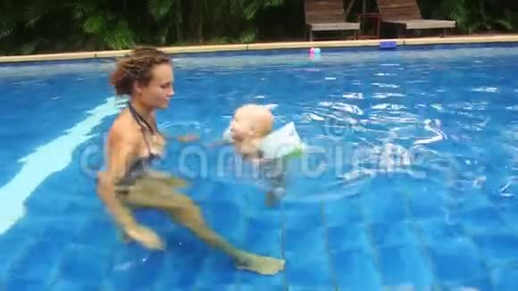 妈妈和女儿正在度假村的游泳池里游泳视频的预览图