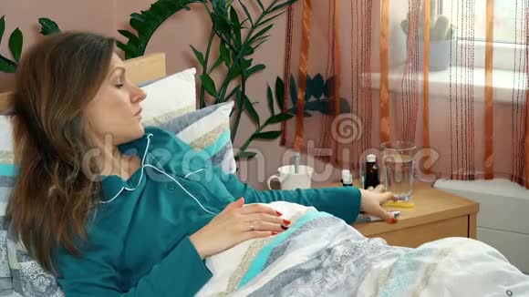 病妇躺在床上用电子体温计测量体温视频的预览图