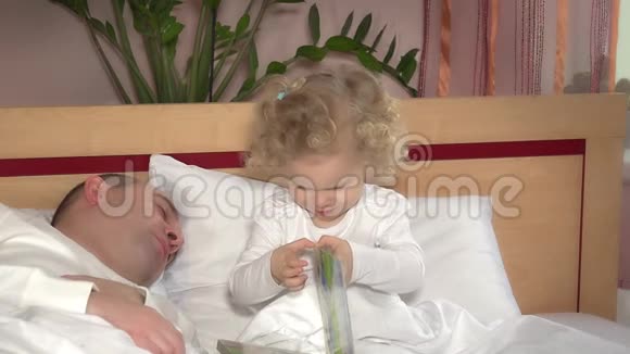 小可爱的女孩醒来她的父亲睡觉拥抱在床上视频的预览图