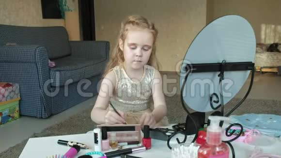 头发红的小女孩把阴影放在眼皮上照镜子化妆脸时尚风格化妆品视频的预览图