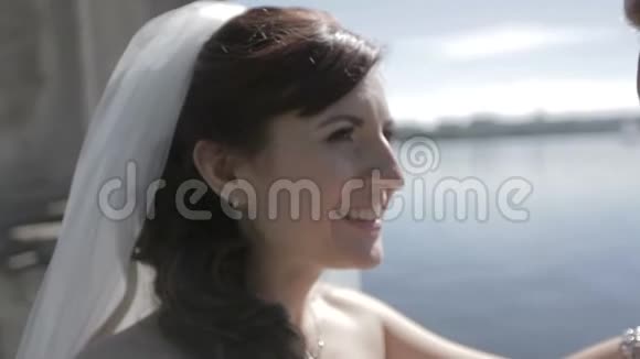 新娘和新郎靠近风景如画的蓝色湖泊肖像画视频的预览图