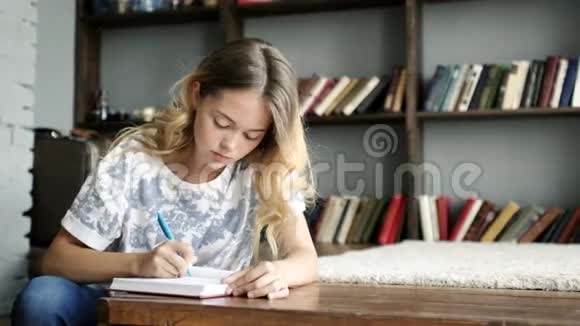 漂亮的少女在学校特写的笔记本上写了一封信视频的预览图