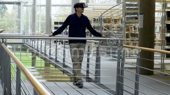 一个戴着虚拟现实耳机站在图书馆的人视频的预览图