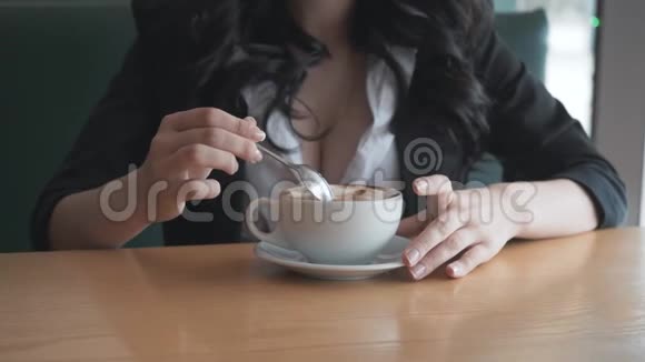 女人用手里的杯子舔咖啡勺视频的预览图