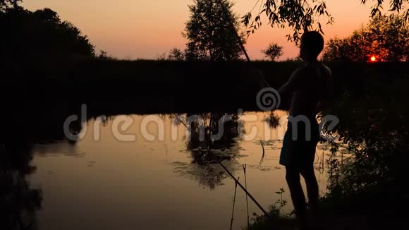 日落时河岸上一个渔夫的剪影视频的预览图