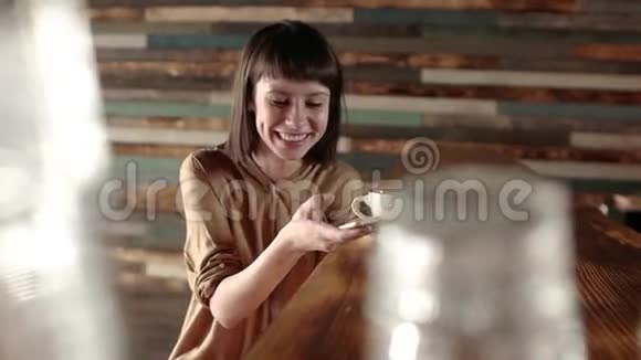女人在智能手机上使用应用程序在咖啡馆快乐的面部表情和手机短信美丽的多元文化青年视频的预览图