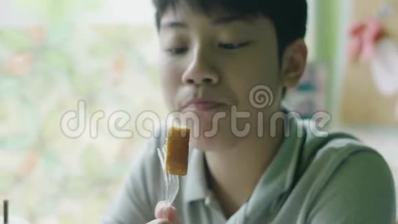 快乐的亚洲男孩喜欢笑着在家吃饭视频的预览图