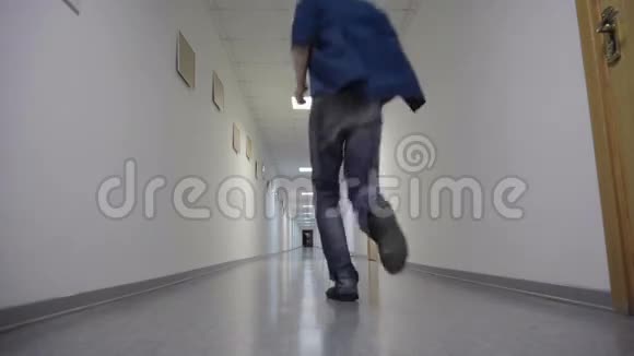 年轻人跑到长长的白色走廊的尽头视频的预览图