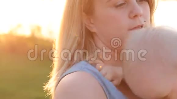 可爱的婴儿在妈妈胸部做梦的女人看日落视频的预览图