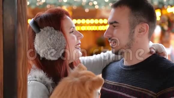 幸福的夫妻有着欢乐的户外活动圣诞节时间及新年理念情人抱着可爱的狗视频的预览图