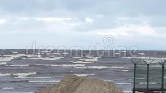 暴风雨中的泡沫波浪雨天录像海上的风暴海浪在卵石石滩上翻滚慢慢视频的预览图
