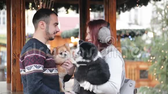 幸福的夫妻有着欢乐的户外活动圣诞节时间及新年理念情人抱着可爱的狗视频的预览图