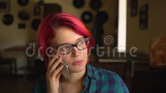 年轻漂亮的女人在智能手机上说话在咖啡馆里眺望视频的预览图