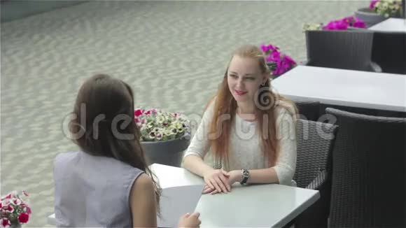 两个女人在咖啡馆里互相讨论视频的预览图
