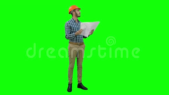 年轻工程师在头盔检查施工图纸上的绿色屏幕铬键视频的预览图