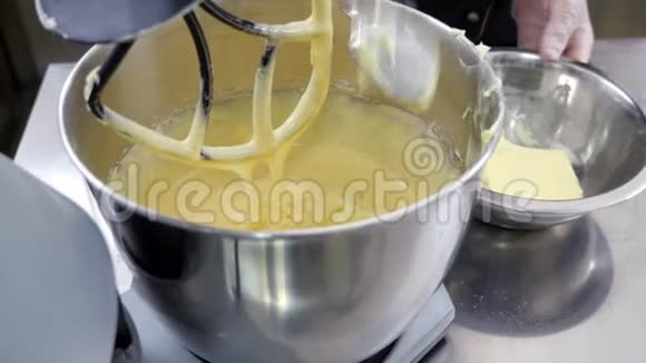 糖果师把黄油放入碗中与奶油混合视频的预览图