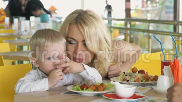 坐在桌旁的小孩子吃着食物视频的预览图