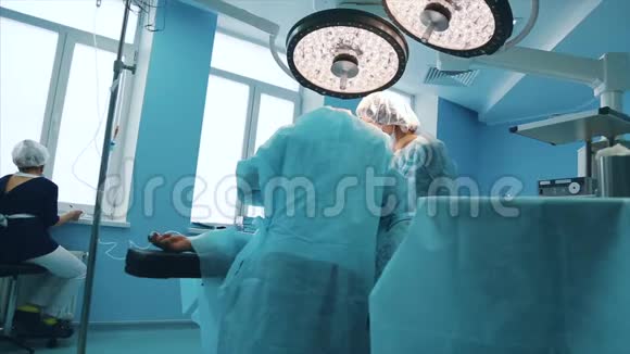 一组专业外科医生对医院手术室的一名病人进行侵入性手术外科医生使用和视频的预览图