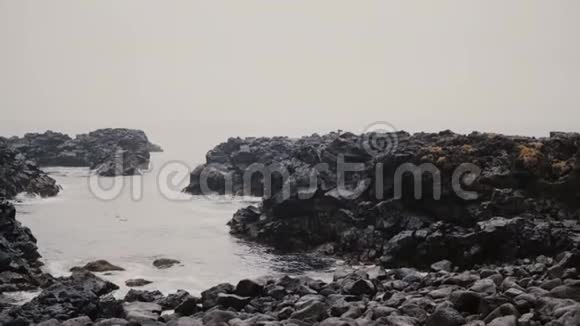 年轻人穿过海边的岩石男子在洛帕皮萨独自探索黑色海滩视频的预览图