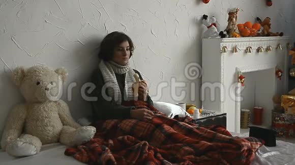 穿毛衣的生病女孩在床上吃香蕉视频的预览图