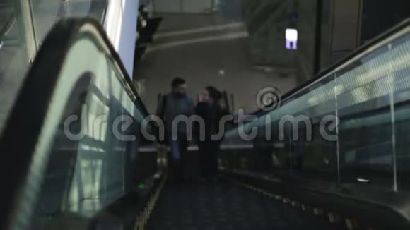 一对情侣的游客站在下一层的扶梯上视频的预览图