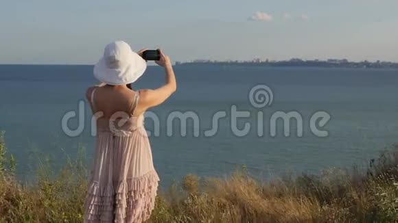 年轻漂亮的女人穿着漂亮的裙子从山顶看日落或日出女孩带着视频的预览图