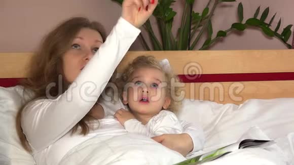 年轻的母亲在天花板上向她可爱的小女孩展示星星视频的预览图