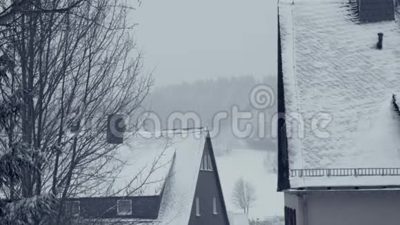家庭房屋的雪屋顶山镇街道村雪灾视频的预览图
