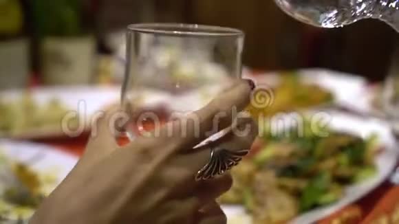 人们在中国餐馆庆祝节日吃传统的中国菜快关门把水倒入玻璃杯里视频的预览图