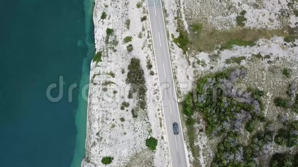 鸟瞰克罗地亚海岸蜿蜒的道路和海湾与晶莹剔透的海洋帕格岛海岸视频的预览图