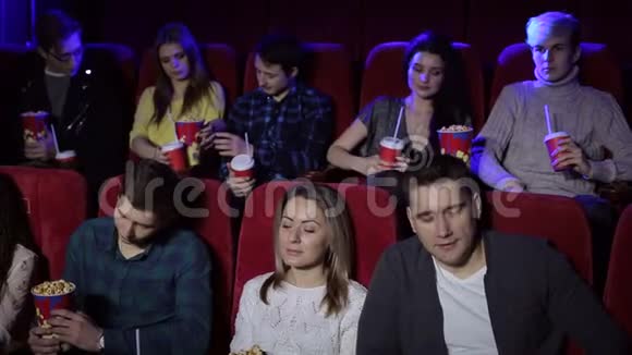 一群青少年朋友在电影院看电影和吃爆米花视频的预览图