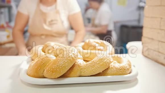 厨师把新鲜的热面包和芝麻放进面包店视频的预览图