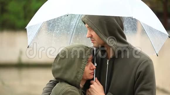 对天气感到失望雨中站在伞下夫妻男人和女人视频的预览图