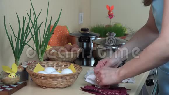 女人用手在厨房里用废料染复活节彩蛋4K视频的预览图