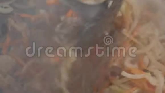 洋葱和大蒜是用肉炒在锅里的用蔬菜烹调炒肉慢动作视频的预览图
