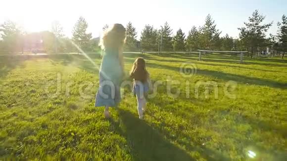 年轻的母亲带着女儿慢动作在户外跑步视频的预览图