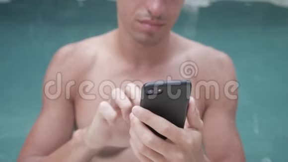 暑假在游泳池里用智能手机的年轻人视频的预览图